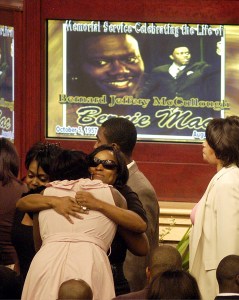 Mourner hugs family member